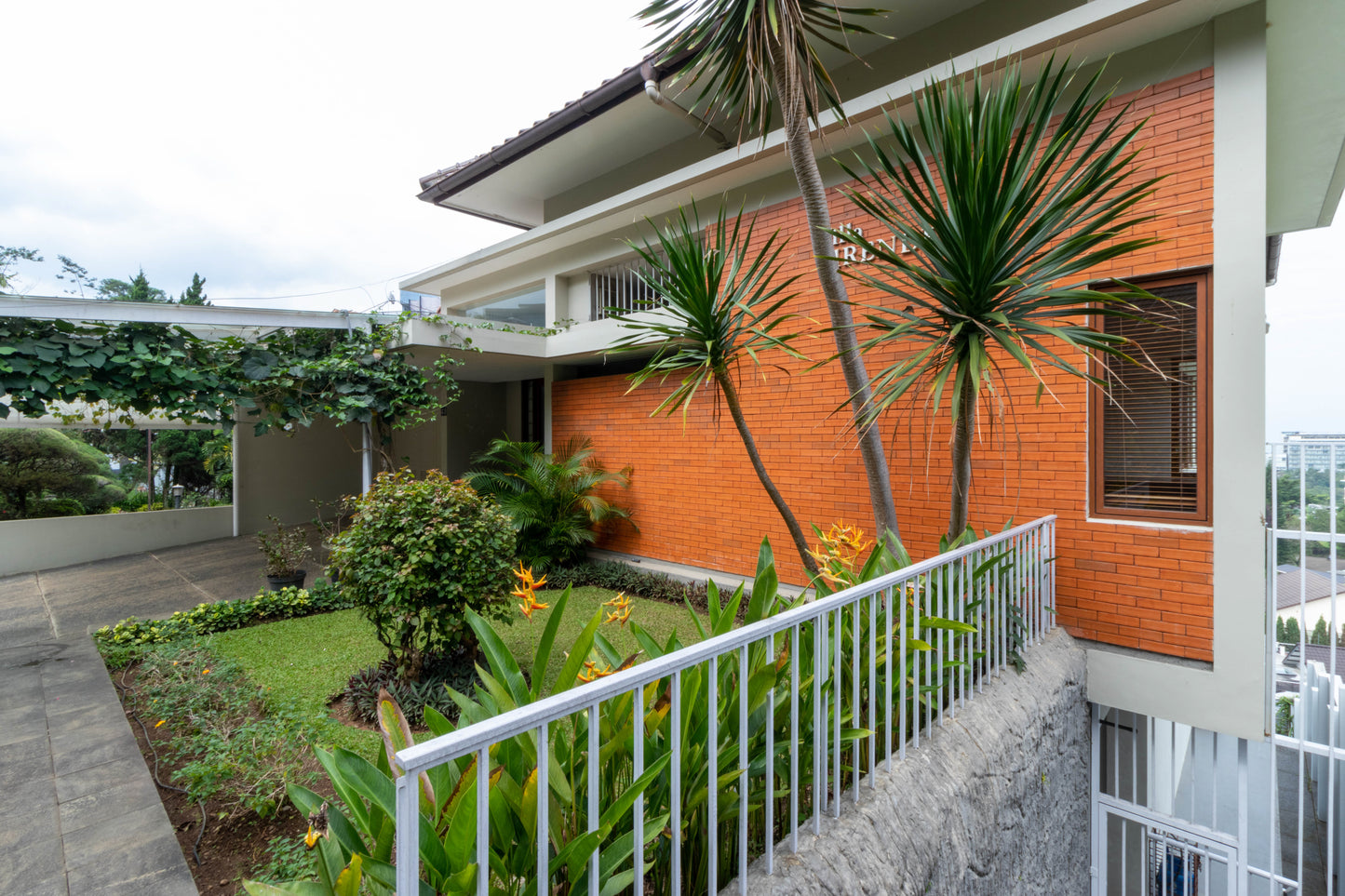 Tampak depan villa dengan batu bata merah dan nuansa modern