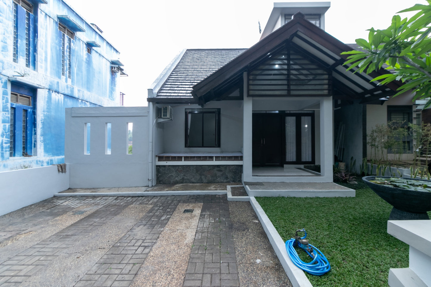 Tampak depan villa modern dengan carport muat 2 mobil