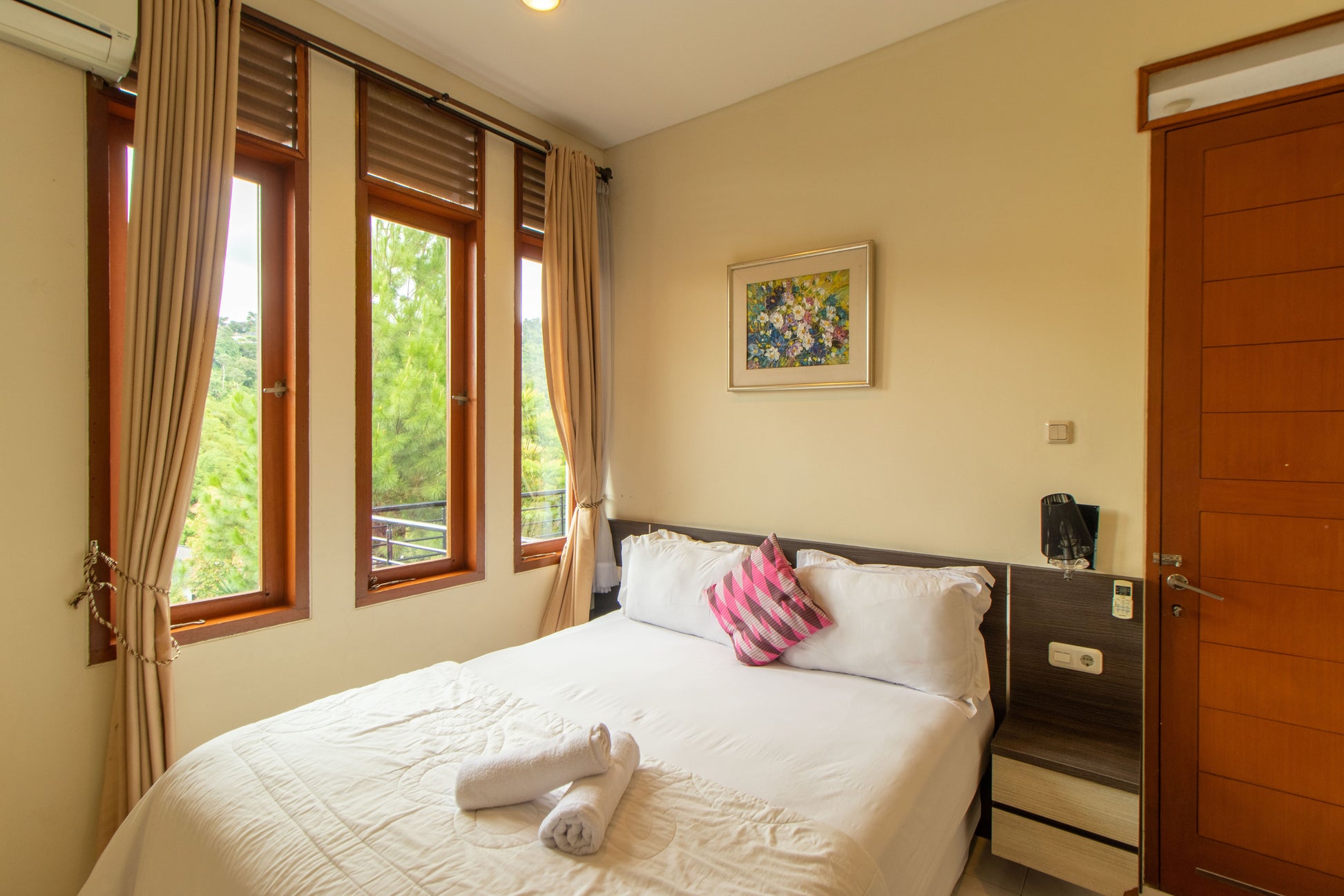 Kamar tidur dengan kasur ukuran queen size ini berada di lantai 1 atau lantai yang sejajar dengan carport, kamar ini bisa kamu jadikan untuk kamar orang tua atau kamar lansia yang sudah tidak bisa naik atau turun tangga, lengkap dengan 2 nakas dan bukaan kaca yang menyuguhkan pemandangan hutan di sekitar villa.