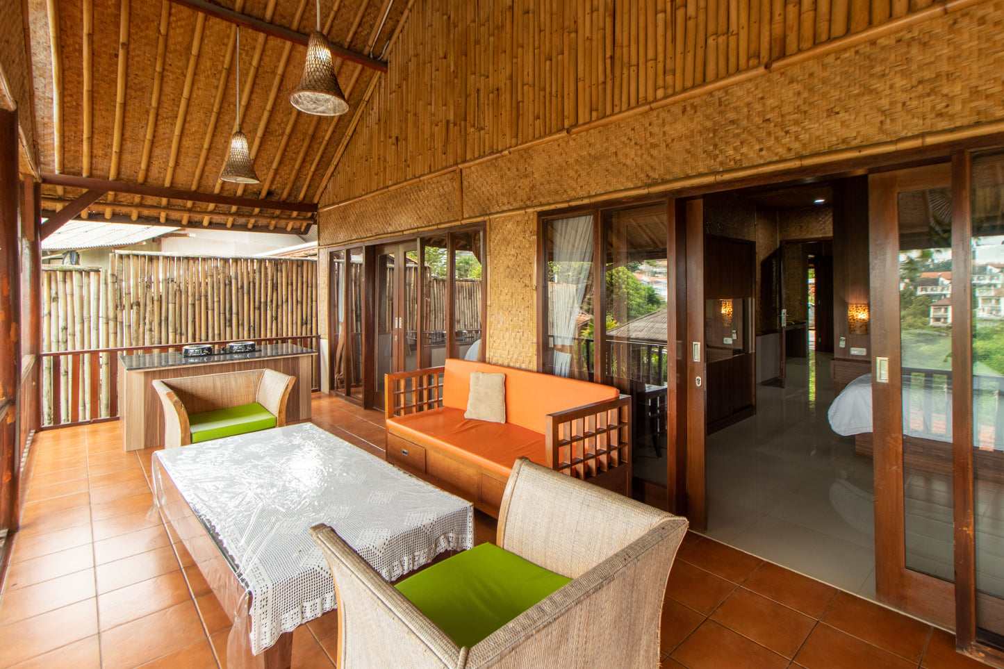 Area kamar tidur yang bisa tembus ke balkon dengan dapur terbuka dan kursi santai dengan lampu gantung diatasnya serta pemdandangan yang langsung menghadap indah nya kota Bandung.