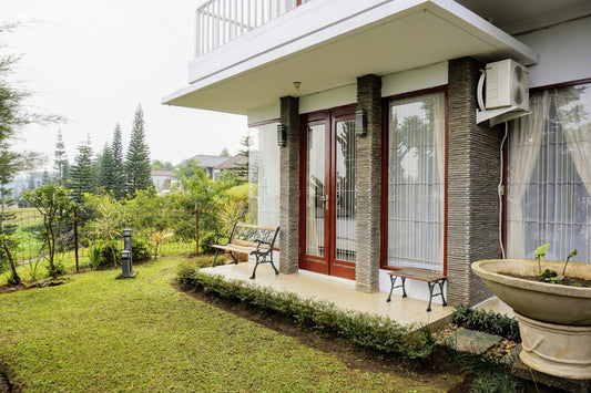 Area taman villa yang asri dengan bangku untuk bersantai