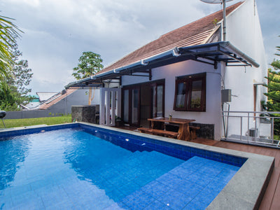 Villa di Bandung dengan kolam renang pribadi yang terletak di lingkungan yang asri, dengan pemanggang luar ruangan dan area tempat duduk nyaman yang terbuat dari kayu jati kokoh