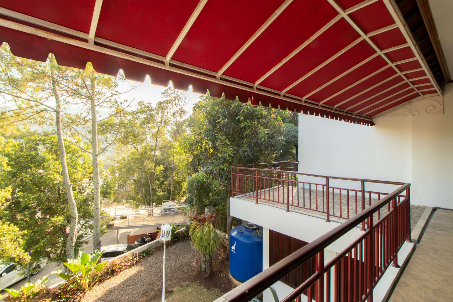 Pemandangan hijau dari balkon Villa Dago35 dengan kanopi merah dan taman asri di bawahnya