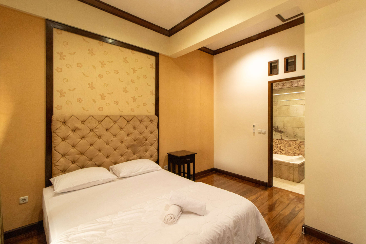 Kamar tidur elegan di Villa Dago35 dengan headboard bermotif berlian dan kamar mandi dalam berbathtub