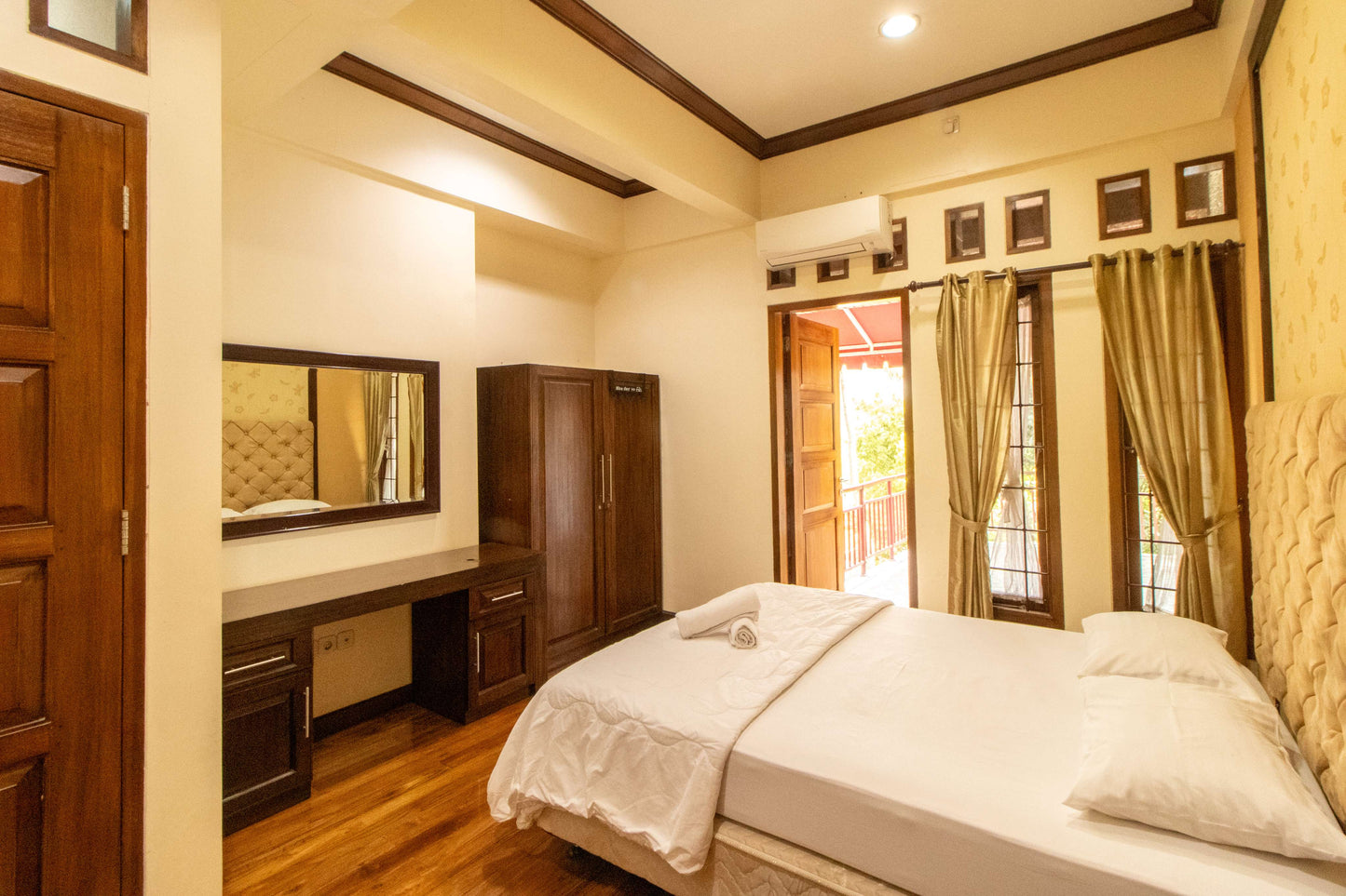 Kamar tidur Villa Dago35 dengan lemari kayu, meja rias, dan akses balkon