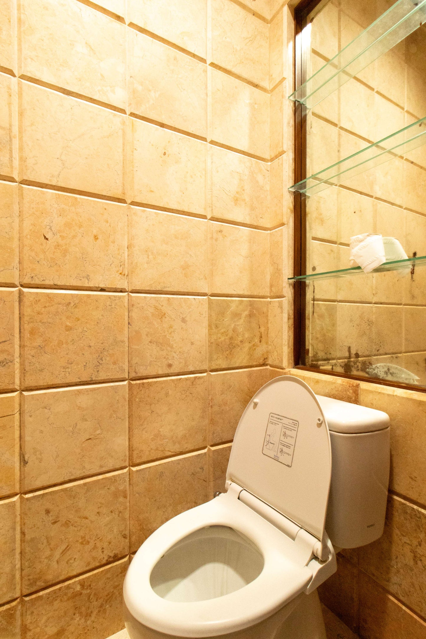 Toilet duduk bersih dengan dinding keramik di kamar mandi Villa Dago35
