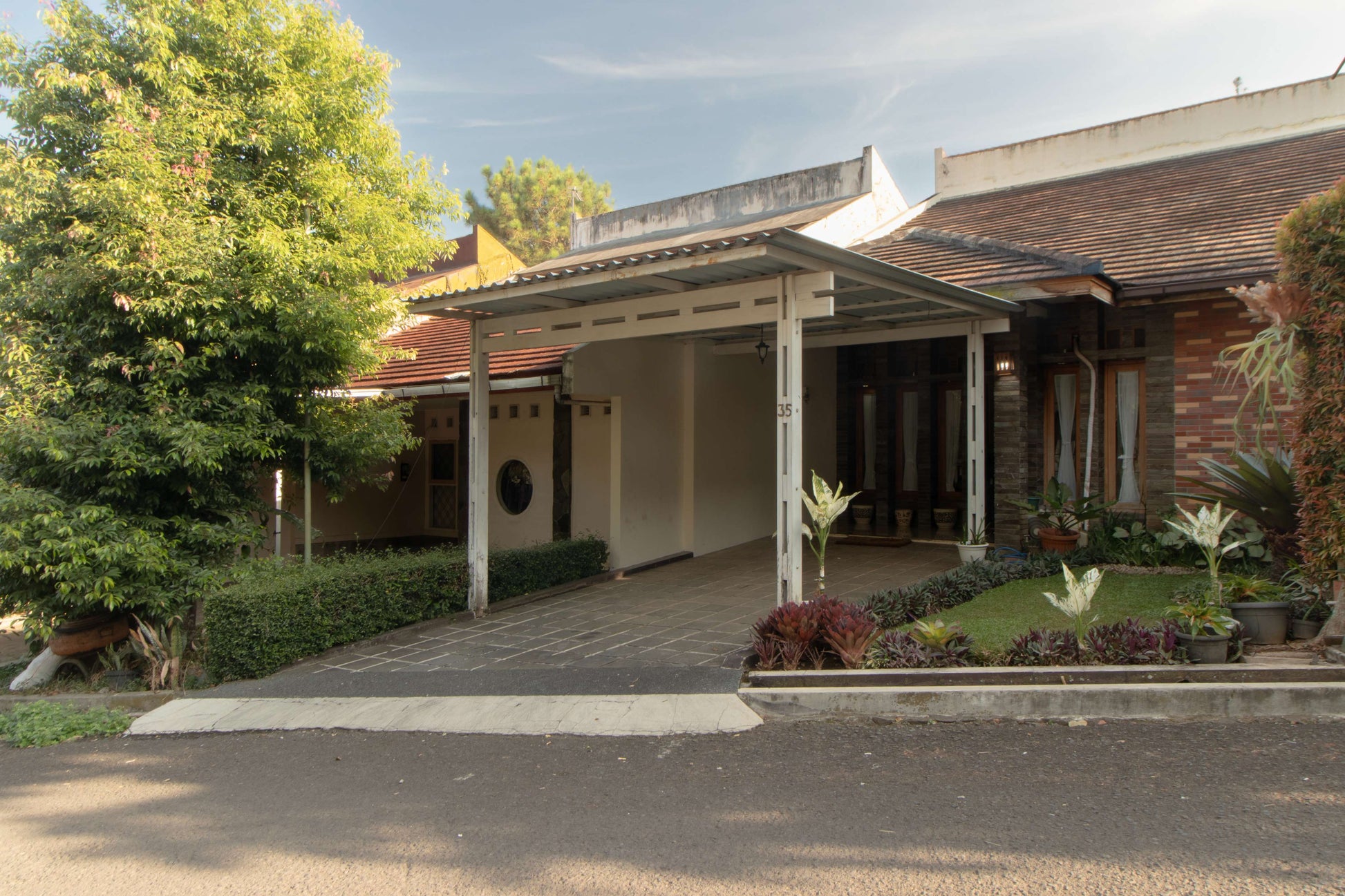 Carport dan area masuk Villa Dago35 dengan atap kanopi dan taman depan yang tertata rapi
