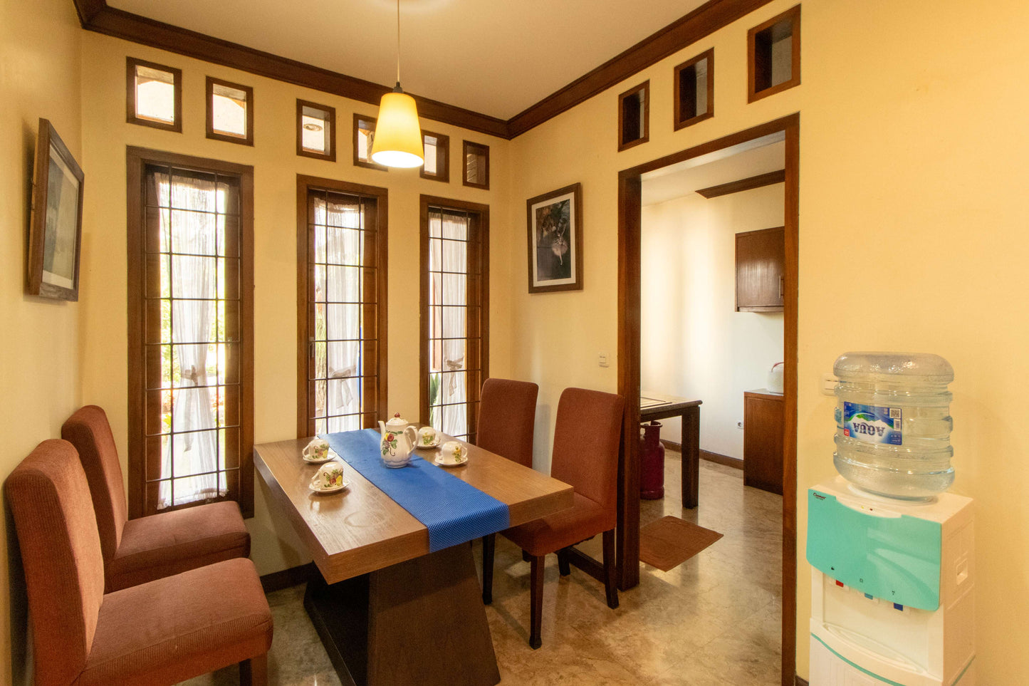 Ruang makan Villa Dago35 dengan set teh di meja kayu dan akses langsung ke dapur