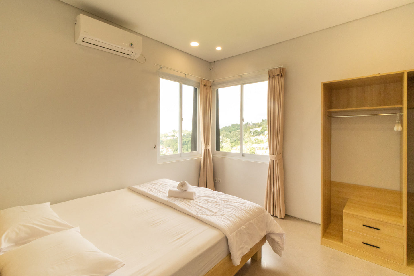 Villa ini memiliki kamar tidur yang dirancang untuk kamu yang menyukai ketenangan. Sentuhan lemari kayu (wooden wardrobe) yang besar tidak hanya memberikan ruang penyimpanan yang melimpah, tetapi juga memberikan aksen warna alami yang hangat di tengah desain kamar yang modern. Dilengkapi dengan AC untuk memastikan suhu ruangan tetap sejuk, kamar ini menjadi tempat yang nyaman untuk beristirahat setelah seharian mengeksplorasi keindahan Bandung.