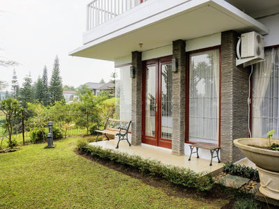 Area taman villa yang asri dengan bangku untuk bersantai
